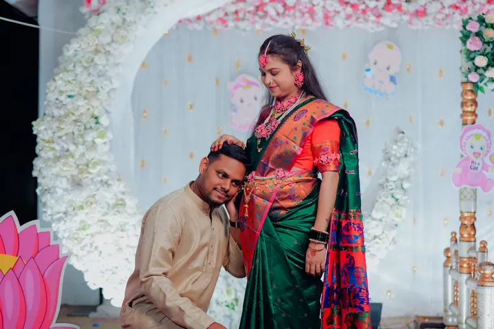 Couple at a traditional Indian baby shower with floral decor